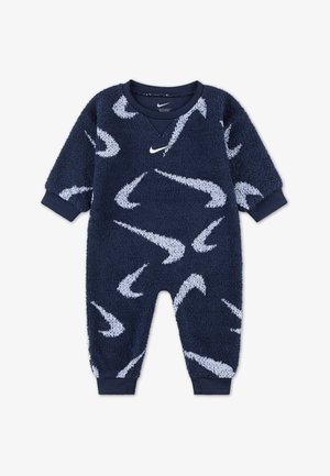 Tuta in pile blu navy con motivi bianchi a forma di swoosh Nike, polsini a coste e scollatura a V. Tessuto morbido e vestibilità comoda per il massimo comfort.