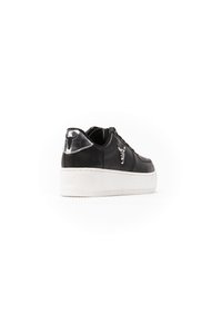 Sneaker nera con tomaia in pelle texturizzata, dotata di un accento metallico sul tallone e suola in gomma bianca. Design della punta arrotondata.