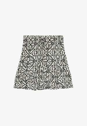 Jupe noire et blanche à motifs, longueur genou, avec des dessins géométriques abstraits et un détail nœud à l'avant à la taille.