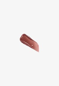 Échantillon de gloss à lèvres rose tonique avec une texture lisse et brillante, une forme incurvée et une légère translucidité sur un fond blanc.