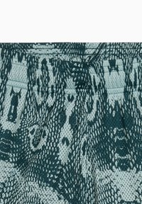 Patterned fabric in shades of teal and cream, featuring a reptile design with a textured mesh finish and subtle detailing throughout.