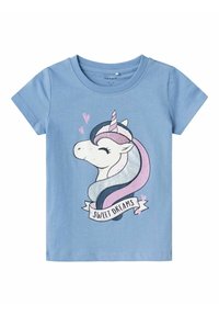 Camiseta de manga corta azul claro con un gráfico de un unicornio con una melena brillante y el texto "Dulces Sueños" en una cinta blanca.
