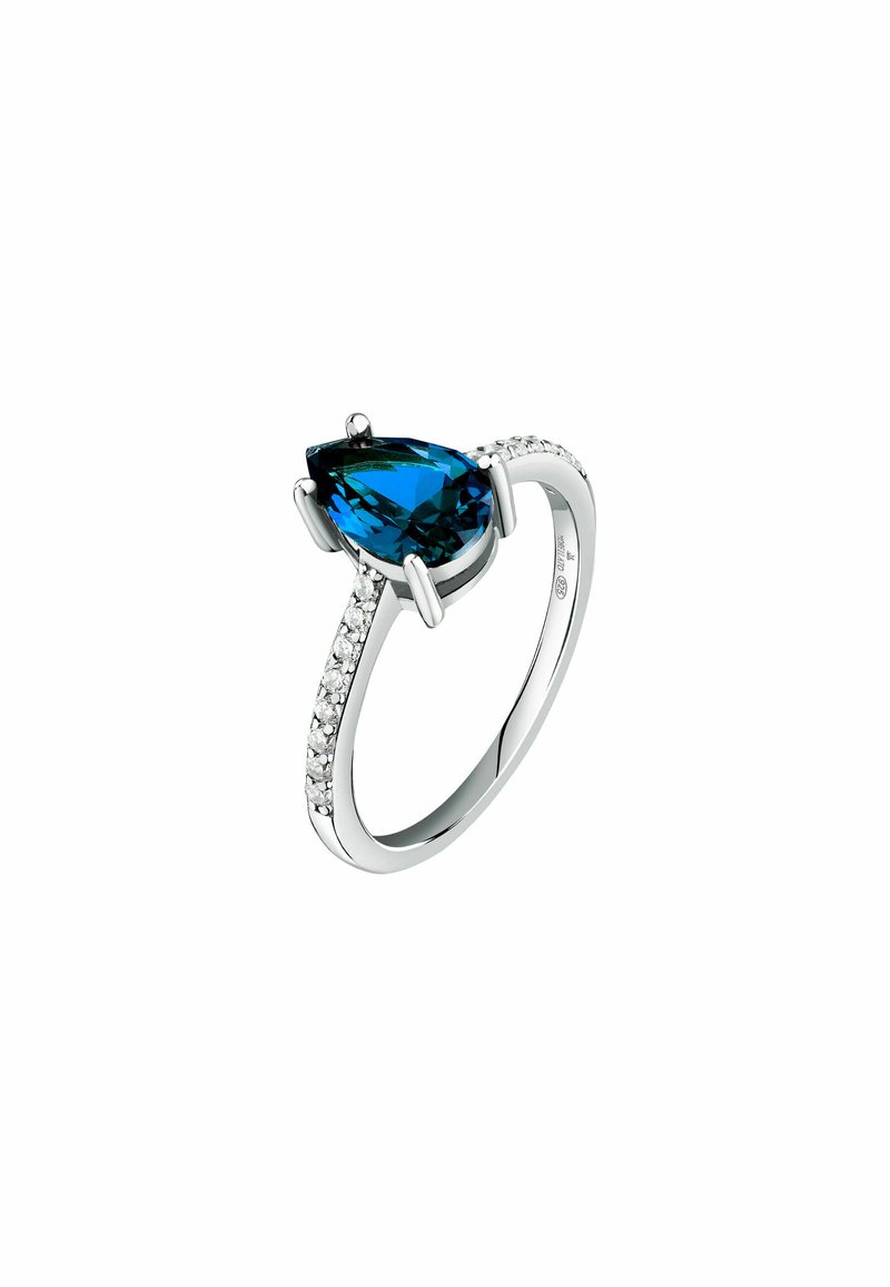 Anello in argento con una grande pietra blu a forma di pera, accentuato da piccole pietre trasparenti lungo la fascia per un tocco di dettaglio in più.