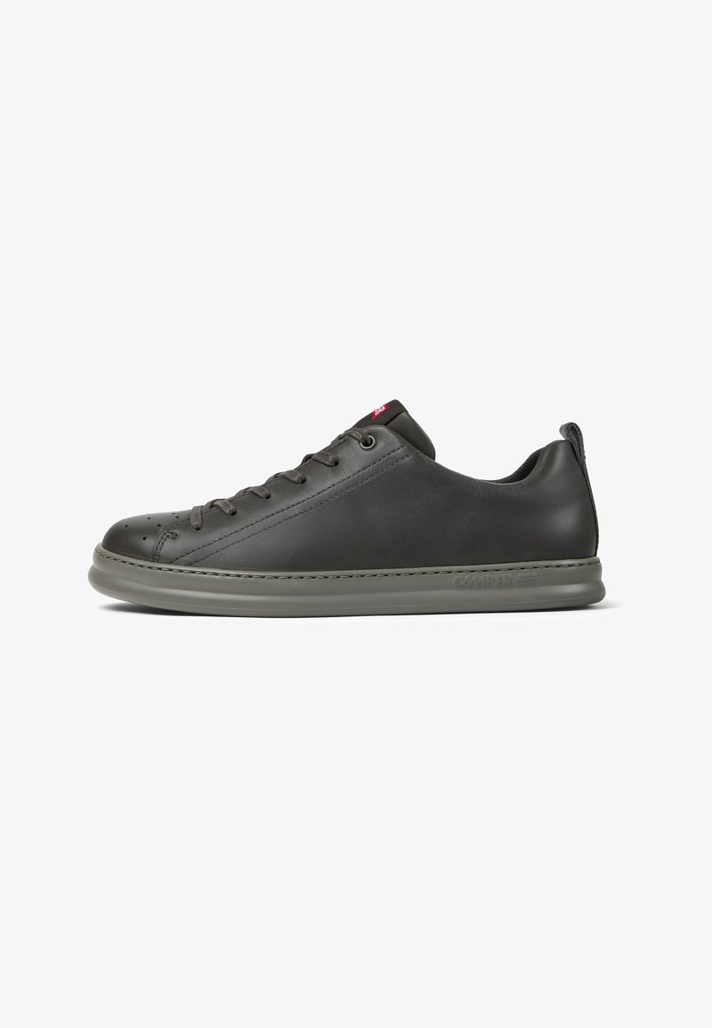 Baskets en cuir noir avec un bout arrondi, une semelle en caoutchouc grise et six œillets. Présentent des perforations subtiles et un accent de logo rouge.