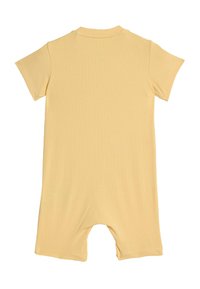 Żółty, prążkowany kombinezon z krótkim rękawem, okrągłym dekoltem i otwartymi nogawkami, wykonany z miękkiej tkaniny o gładkiej teksturze i minimalistycznych detalach.