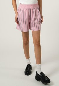 Shorts rayés roses avec un waistband élastique, fabriqués en tissu léger, présentant des rayures verticales bleu foncé et des poches latérales.