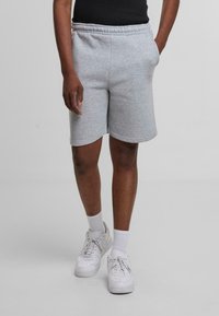 Grå bomuldsblandede shorts med elastisk talje, sidelommer og lige snit, parret med hvide sneakers og ankelsokker.