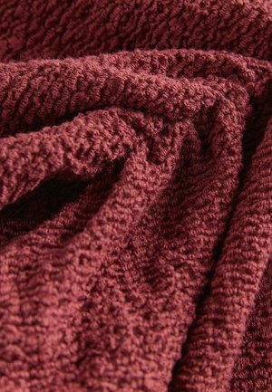 Textúrovaná látka v hlbokej burgundskej farbe s jemným, hrbolkovým povrchom, zobrazuje robustný tkaný vzor a krčené záhyby.