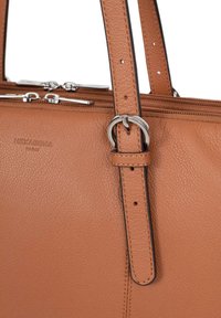 Borsa a tracolla in pelle di colore marrone con due manici, caratterizzata da un accento in metallo argentato e chiusura a zip. Nome del marchio impresso sul lato.
