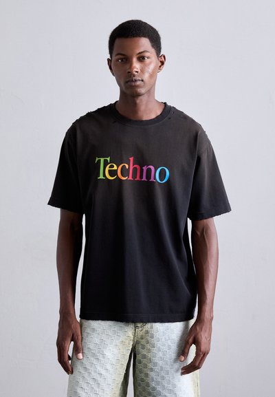 Fekete pamut póló, színes "Techno" grafikával. A dizájn laza szabású és viseltes nyakrésszel rendelkezik. Könnyű, strukturált farmernadrággal ajánlott párosítani.