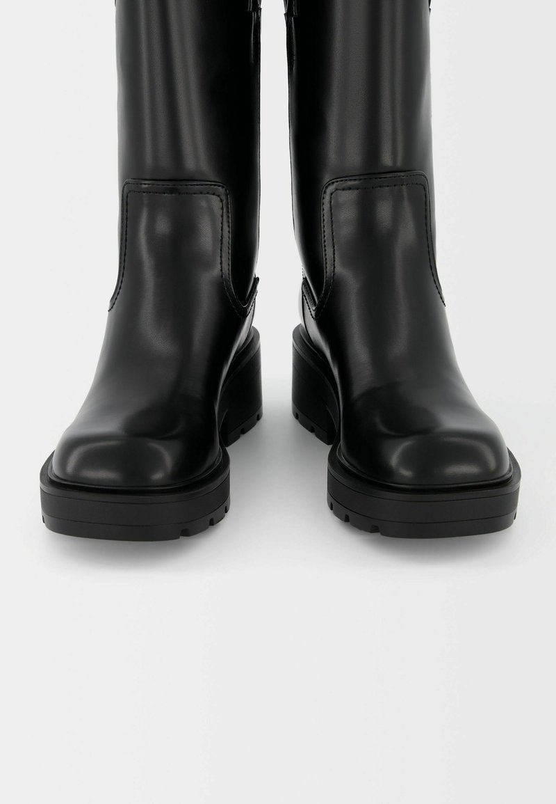 Stivali neri in pelle al ginocchio con finitura testurizzata, robuste tacchi a blocco, punte arrotondate e dettaglio con zip laterale per una facile calzata.