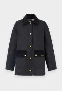 Black quilted jacket with gold hardware, corduroy pockets, and collar; features diamond pattern and branding on the lower pocket.