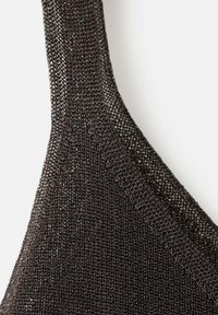 Bretelele unui bralette negru tricotat, având un material transparent, texturat cu o țesătură fină. Marginile sunt finisate cu o cusătură netedă.