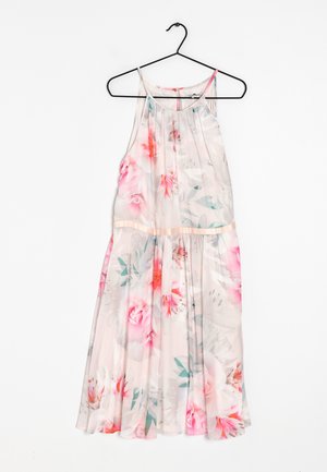 Vestido floral sin mangas de color rosa claro con escote halter colgado en una percha negra sobre fondo blanco.