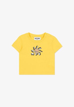 Maglietta di cotone gialla con grafica di un orso marrone stampato e scritta "MOSCHINO" in stili diversi intorno; presenta bottoni automatici sulla spalla.