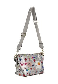 Bolso bandolera plateado sintético con patrones coloridos de estilo caricaturesco, que incluyen un huevo, mariquitas y varias formas, con una correa desmontable.