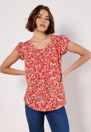 Blusa rossa floreale con maniche a palloncino corte, scollo arricciato e vestibilità ampia. Presenta un vivace motivo floreale su uno sfondo luminoso.