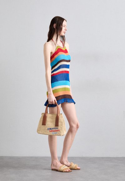 Rochie tricotată cu dungi multicolore, cu un design fără mâneci și tiv ondulat. Geantă țesută cu mânere bej și text brodat. Sandale plate.