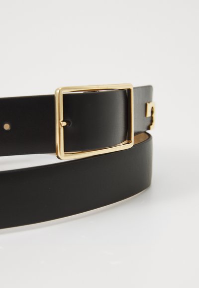 Črn usnjen pas z zlatim pravokotnim sponko, gladka tekstura in več luknjic za prilagoditev dolžine pasu.