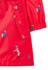 Röd vattentät jacka med illustrationer av hundar i kläder och en kanin. Slät textur, elastiska ärmslut och en framficka.