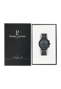 Reloj cronógrafo negro con una esfera azul oscura, correa de malla y caja negra, presentado en una caja negra con un diseño minimalista del horizonte de París.