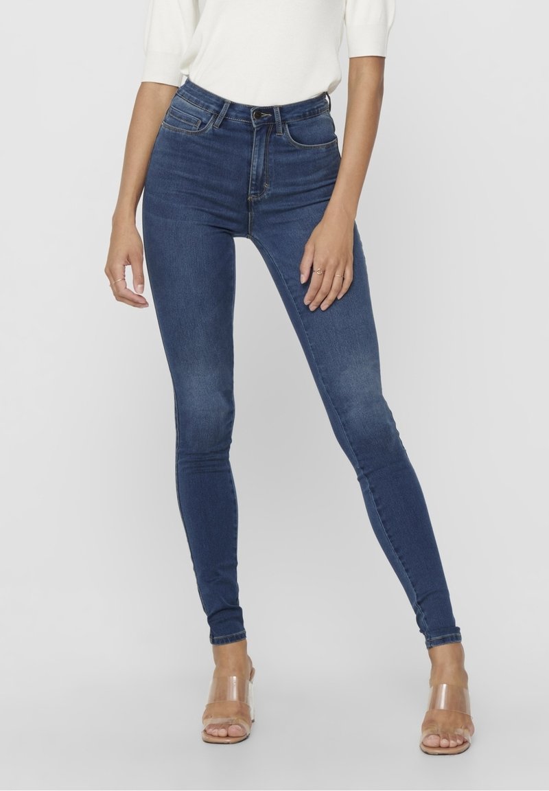 Jeans ajustados de tiro alto en azul, elaborados con mezclilla, que presentan una textura suave, un diseño clásico de cinco bolsillos y un cierre de cremallera con botón.