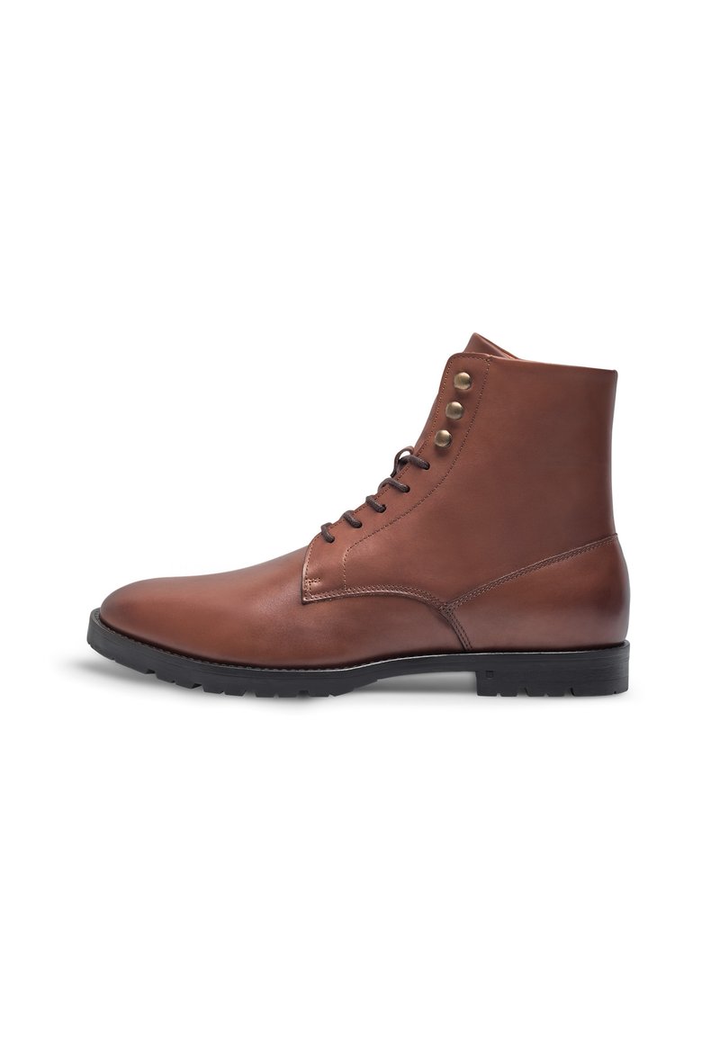 Stivaletto in pelle marrone con una texture liscia, punta arrotondata e tre occhielli in bronzo. Suola in gomma nera per una migliore aderenza.