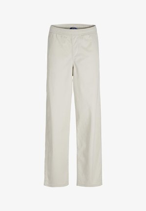 Felpa verde con testo giallo "JACK&JONES" e logo, polsini e orlo a coste, abbinata a pantaloni bianchi e sneakers bianchi.