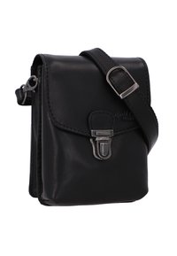 Musta nahkainen olkalaukku, jossa on läppä, metallilukko ja säädettävä hihna. Ominaisuuksiin kuuluu sileä pinta ja hillitty brändäys.