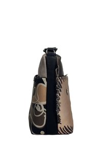 Zweifarbige Lederhandtasche in Beige und Schwarz mit auffälligen abstrakten Mustern, einer strukturierten Form, einem oberen Griff und dekorativen silbernen Beschlägen.