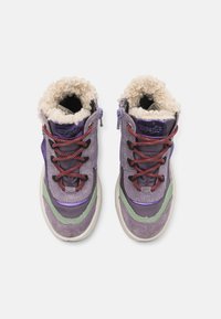 Tige violette et grise avec des panneaux texturés, doublure en fausse fourrure, lacets multicolores et semelle blanche épaisse. Comprend une fermeture éclair sur le côté.