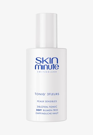 Bouteille blanche de tonique facial Skin Minute Switzerland étiquetée "TONIQ' 3FLEURS" pour peau sensible avec texte multilingue en police bleue.