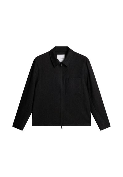 Svart jacka med dragkedja, krage, rak skärning, långa ärmar och en bröstficka. Texturerat tyg med subtil väv.