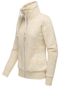 Felpa beige chiaro con colletto alto, motivo floreale, zip frontale e lacci. I polsini e l'orlo a coste aggiungono texture.