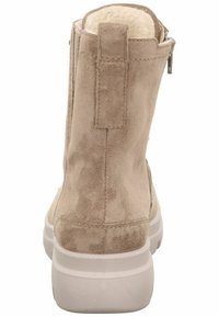 Botín de tobillo de ante beige con un forro suave, detalle de costura vertical y cierre lateral; cuenta con una suela de goma blanca para mayor tracción.