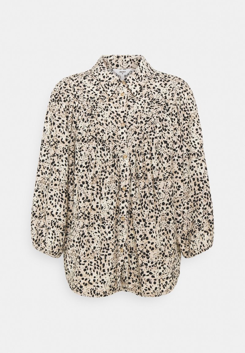 Blouse en imprimé léopard beige avec des taches noires, dotée d'un col, d'une fermeture à boutons et de manches bouffantes élastiques. Tissu léger et texturé.