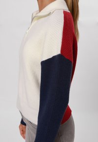 Pullover lavorato a maglia con zip a un quarto, caratterizzato da colori crema, rosso e blu navy, texture a coste sulle maniche e sul corpo, silhouette aderente.