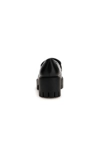 Scarpe platform in pelle nera con suola spessa, caratterizzate da una punta arrotondata e dettagli di cucitura discreti sul tallone.