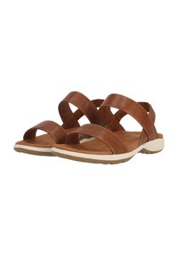 Sandales en cuir marron avec de larges sangles croisées, une semelle intérieure rembourrée et une semelle en caoutchouc blanc avec un motif de texture.