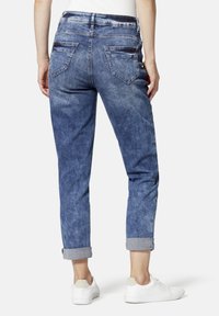 Jeans in Hellblau mit lockerem Schnitt, umgeschlagenen Säumen und zwei Gesäßtaschen. Der Stoff wirkt ausgeblassen und hat eine glatte Textur.