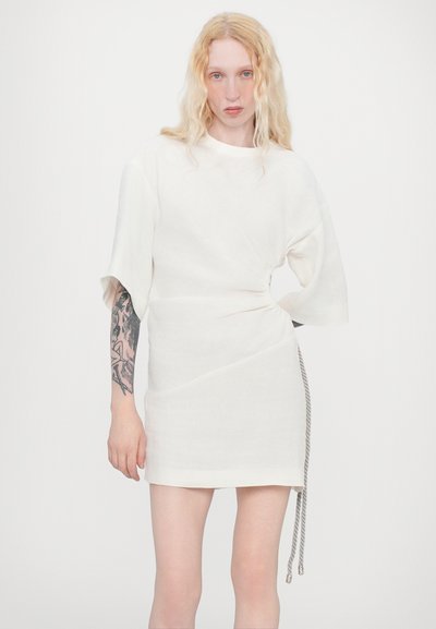 White wrap dress in a lightweight fabric, featuring short sleeves, a side tie detail, and a subtle textured finish.