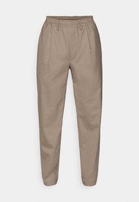 Pantaloni bej, ușori, cu un elastic la talie, două pliuri frontale și picioare îngustate. Textură netedă cu linii clare și fără modele vizibile.