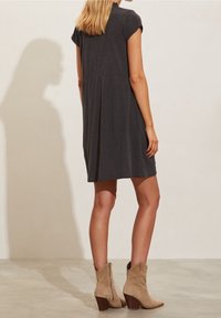 Grå kortärmad klänning med lös passform och insamlad ryggdetalj, parat med beige mocka ankelstövlar med klack.