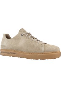 Beige semskinn sneakers med en glatt tekstur, rund tå og snøredesign. Har en tan gummisåle med en subtil korkdetalj.