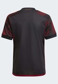 Mustat pelipaita, jossa on punaiset korostuskuviot olkapäillä ja hihoissa. Varustettu kauluksella ja "DEUTSCHLAND"-tekstillä kultaisella värillä takana.