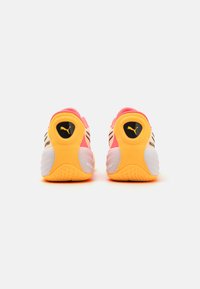 PUMA sneakers med en pink mesh-overdel, klare gule accenter, sort logo og en struktureret hvid og orange ydersål.