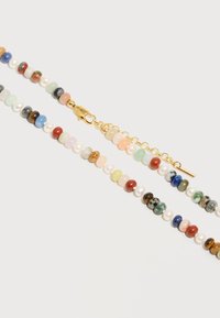 Collier avec perles rondes multicolores comprenant des perles et des pierres, doté d'un fermoir homard en or et d'une chaînette d'extension réglable.