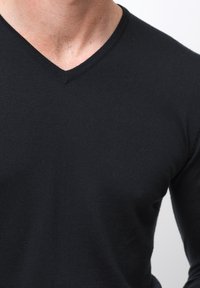 Svart, figurnära långärmad T-shirt med V-ringning, med en slät textur och ribbad halsringning. Inga synliga mönster eller detaljer.