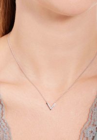 Zilveren ketting met een V-vormige hanger met een gepolijste afwerking en ingelegde heldere stenen, opgehangen aan een delicate ketting.
