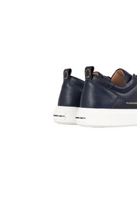 Sneaker in pelle blu navy con finitura texture, suola bianca e accenti del marchio a contrasto sul tallone e sul lato, dotati di linguette per il trasporto.